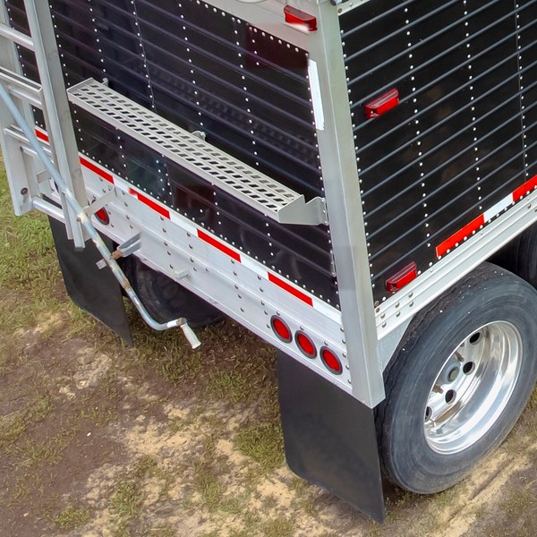 Rear of a grain hopper trailer with plain black rubber mud flaps behind the wheels (illustrative photo)
